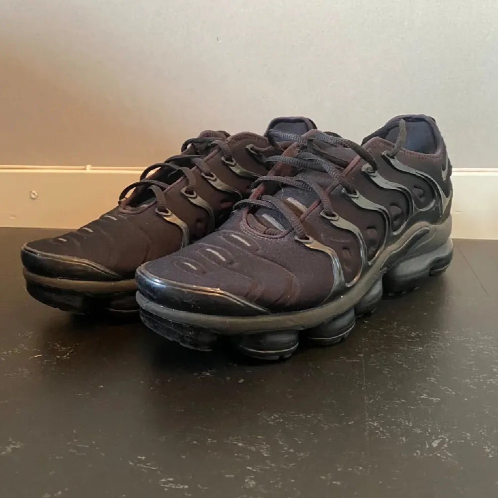 Säljer ett par svarta Nike Air Vapormax i bra skick. De har en cool design med synliga luftkuddar i sulan och snörning för bra passform. Perfekta för både träning och vardagsbruk. Skorna är bekväma och ger bra stöd.. Skor.