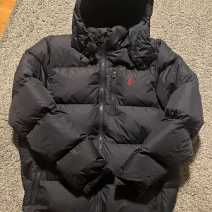 Ralph Lauren jacka - Tvärsnygg och trendig Ralph Lauren jacka som är perfekt till vintern. Ny kostar denna jacka 4500, mitt pris 2500. Jackan är i bra skick ända defekten är vid armhålan där det finns ett litet hål. Hålet är sytt och syns inte vid användning (se bild 5). Hör av dig vid frågor❄️ //Tom