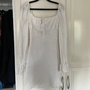 Vit klänning från ADOORE - Säljer en superfin vit klänning från ADOORE i storlek 38. Den har långa ärmar och ett vackert spetsmönster. Perfekt för sommarens fester eller studenten. Klänningen har en smickrande passform och är i mycket bra skick.