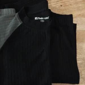 Svart ribbad tröja från Trekmates    två tröjor med ett par byxor M kinley stl 158/164 - Säljer en svart ribbad tröja från Trekmates i storlek 160. Perfekt för kyliga dagar med sitt bekväma och stretchiga material. Tröjan har långa ärmar och en klassisk design som passar till det mesta. Perfekt för både vardag och friluftsliv!