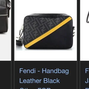 Svart handväska i skinn från Fendi - Säljer en snygg svart handväska i skinn från Fendi med ett coolt gult diagonalt band. Väskan har Fendi-loggan i ett mönster över hela ytan och en praktisk dragkedja. Perfekt för att ge din outfit en lyxig touch! Vet inte riktigt om den är äkta där jag fick den som födelsedagspresent.. men tänker den är skit snygg men använder inte den!
