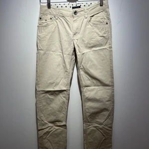 Beigea chinos - Säljer ett par snygga beigea chinos i bra skick.  Perfekta för både vardag och lite finare tillfällen. Passar bra till höst och vår. Små defekter på ena byxan syns knappt (se bild 2) Skulle säga att storleken går att jämnföra med storlek 44 så väldigt små (XS) i midjan