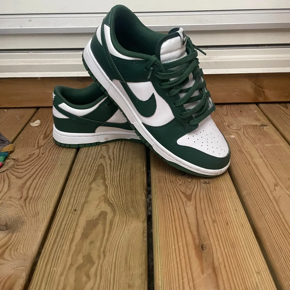 Säljer ett par snygga Nike Dunk sneakers i grönt och vitt. De har en klassisk design med snörning och är i mycket bra skick. Box tillkommer! 899kr pris! . Skor.