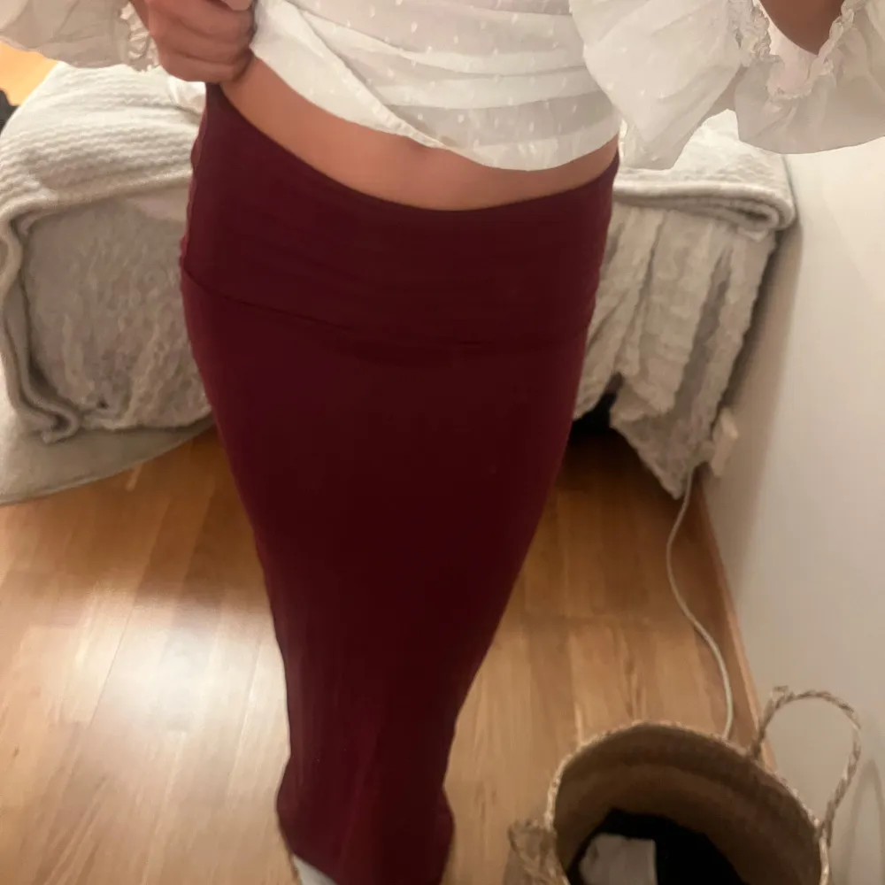 Säljer en snygg vinröd långkjol som sitter tight och är perfekt för både vardag och fest. Kjolen är i ett mjukt och stretchigt material som gör den superbekväm att ha på sig. Passar perfekt till en vit blus eller en stickad tröja. Perfekt för höst och vinter!. Hameet.