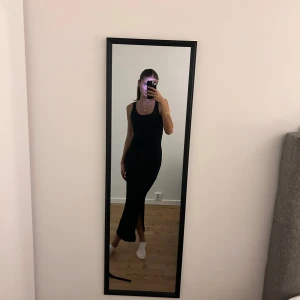 Svart klänning från Pieces - Snygg svart långklänning från Pieces med 2 slits på varsin sidan. Klänningen är ärmlös och har en figurnära passform, perfekt för en stilren look.