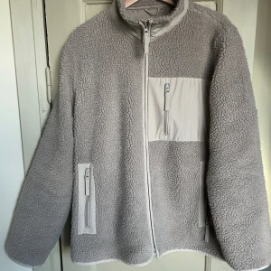 A Days March fleecejacka - Mysig grå fleecejacka med dragkedja och praktiska fickor. Perfekt för kyliga dagar med sin mjuka och varma känsla. Storlek L