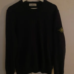 Svart tröja från Stone Island - Säljer en stilren svart tröja från Stone Island med deras ikoniska märke på ärmen. Tröjan har en klassisk passform och är i storlek M. Knappt använd då den inte passar.
