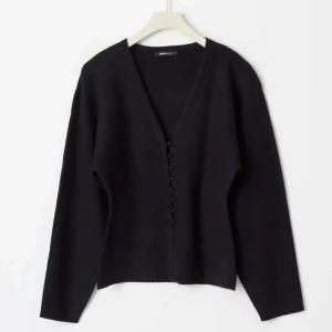 Svart kofta från Gina Tricot - Snygg svart kofta från Gina Tricot med v-ringning och knappar framtill. Helt slutsåld, storlek S. Använd en gång