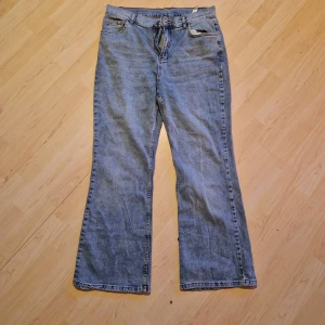 Blå jeans med vida ben Storlek L - Snygga blå jeans med vida ben och hög midja. Klassisk femficksdesign med dragkedja och knapp framtill. Flare jeans. I storlek L
