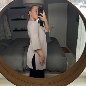 Puderrosa kappa med trekvartsärm - Elegant puderrosa kappa med trekvartsärm och öppen design. Perfekt för lager-på-lager och ger en stilren look. Passar bra till både vardag och mer uppklädda tillfällen. Normal i storleken 