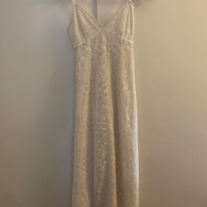Vit spetsklänning från Zara - Elegant vit midiklänning från Zara med vackert spetsmönster. Klänningen har smala axelband och en v-ringad design som ger en romantisk känsla. Perfekt som studentklänning. 💗Storlek s men passar nog både xs-s. Skriv för fler bilder!