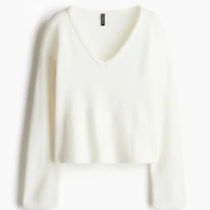 Vit v-ringad tröja  - Säljer en stilren vit tröja med v-ringning. Tröjan är croppad och har långa ärmar, perfekt för en avslappnad look. Passar bra till jeans eller kjol. Storlek L men sitter som M 