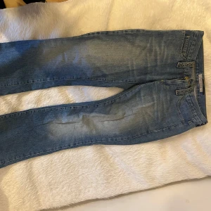 Lågmidjade utsvängda jeans  - Trendiga jeans med metal detaljer. Väldigt fint skick förutom att de är lite nedtrampade, men det är inget man tänker på och ser coolt ut. Pris kan diskuteras vid snabb affär