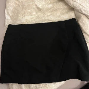 Svart kjol med lågmidja - Svart Lowwaist kjol från pull&bear, tyvärr lite stor på mig. Omlott design.