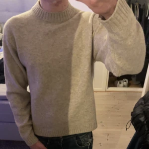 Beige tröja från Uniqlo - Säljer en stilren beige tröja från Uniqlo. Tröjan är tillverkad i en mjuk blandning av akryl och polyester, vilket gör den både bekväm och hållbar. Den har en klassisk rund hals och långa ärmar, perfekt för kyligare dagar. Pris går att diskuteras vid snabba affär🤩