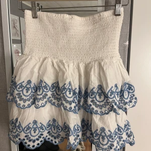 Vit kjol med blå detaljer från Lindex - Jättefin kjol från Lindex med fina blåa detaljer. Storlek 170 men passar xs/s