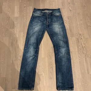 Blå jeans från Nudie Jeans - Säljer mina nudie jeans som är i storlek 31/34. Denna modell heter average joe och sälj inte längre. Den har inga skador förutom lite heeldrag. Passformen är straight. 