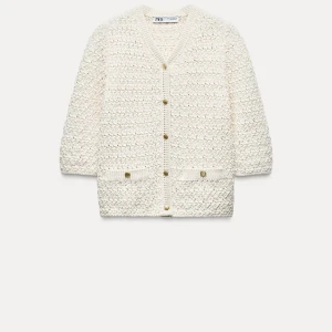 Vit kofta från Zara - Säljer en stilren vit kofta från Zara med v-ringning och knappar framtill. Koftan har en texturerad yta och trekvartsärmar, perfekt för lager-på-lager-stil. Ett måste i garderoben för en chic look!