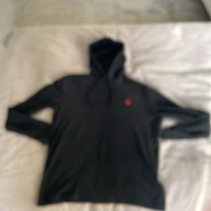 Svart ralph lauren hoodie - Säljer en snygg svart ralph lauren hoodie med röd logga på bröstet. Nypris på den är 1200.