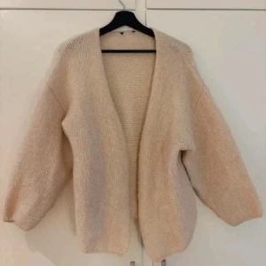 Beige stickad kofta från Lindex - Mysig beige stickad kofta från Lindex. Perfekt för kyliga dagar med sin öppna design och mjuka material. Koftan har en avslappnad passform och långa ärmar. Ett stilrent plagg som enkelt kan matchas med olika outfits. Mycket fint skick, bortklippt lapp i nacken då den skav😅❤️