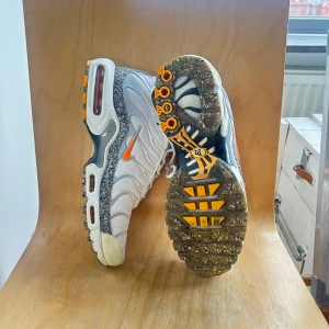 Nike Air Max TN Deadstock - Nike Air Max sneakers i vitt med grå och orange detaljer. Skorna har en unik sula med synlig luftdämpning och Tn-logga på hälen. Skick 9/10. Köpta för 2399kr.