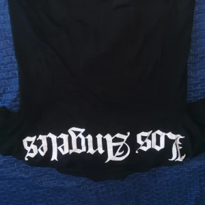 Svart t-shirt med Los Angeles-tryck - Snygg svart t-shirt med texten 'Los Angeles' i vit stilfull font. Perfekt för en avslappnad look.