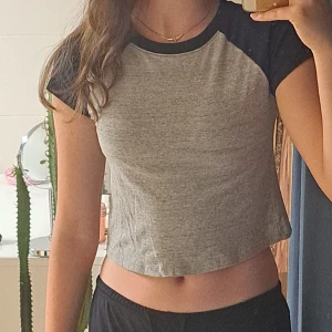 Kort t-shirt - Grå och mörkbå trendig t-shirt från superdry. Använd ett fåtal gånger och säljer för att den inte används. Bra skick!