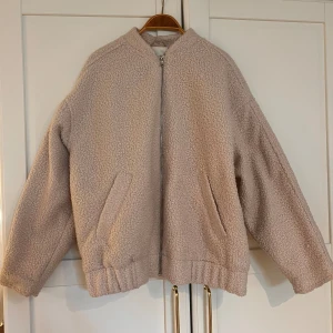 Teddy bomberjacka - En beige bomberjacka i Teddy material i storlek S, säljer den då den inte har kommit till användning och är därav i nytt skick. 