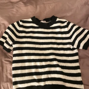Stickad T-shirt  - Det är en randig stickad t-shirt ifrån H&M den är nopprig så det svarta har kommit över det vita men tror det kan gå bort 