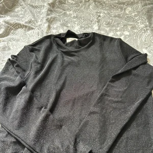 Tröja - Glittrig svart tröja 