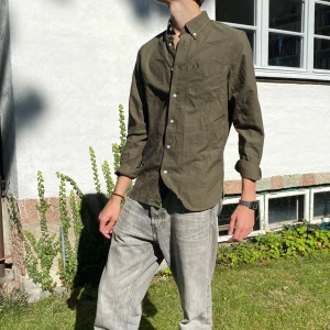 Olivgrön Fred Perry skjorta  - Skitsnygg olivgrön skjorta från Fred Perry. Knappt använd, inga defekter! Perfekt om man vill blanda in lite färg i outfiten men ändå vara diskret🦦 Nypris 1500kr