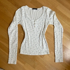 Brandy melville långärmad tröja - Söt långärmad tröja från Brandy Melville med ljus blå blommor och pointelle material ☺️
