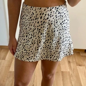 Leopardmönstrad kjol från Gina Tricot - Snygg leopardmönstrad kortkjol från Gina Tricot i en beige och svart färgkombination. Kjolen har en normal passform och är perfekt för att ge en trendig touch till din outfit. 🐆