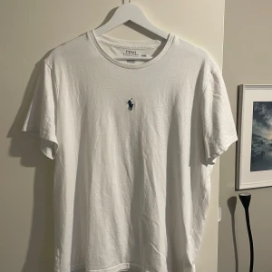 Vit t-shirt från Polo Ralph Lauren - Säljer en klassisk vit t-shirt från Polo Ralph Lauren i storlek L. T-shirten har en broderad logga på bröstet. T shirt en är i riktigt fint skick och sällan använd. Passar L/M