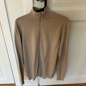 Beige full zip från selected home - Säljer min fullzip från selected home! Stilren och passar till allt från hemmakväll till utekväll!