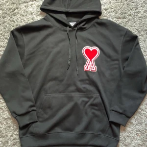 Svart ami paris hoodie - Säljer nu en svart ami paris hoodie i riktigt bra skick. Den är i storlek M och har inga defekter eller liknande. Vid frågor och funderingar är det bara att höra av sig.