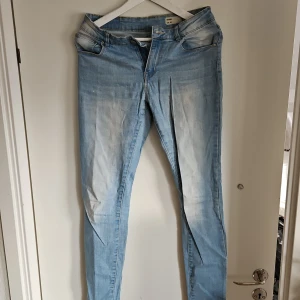 Ljusblå jeansbyxor - Snygga ljusblå jeansbyxor med en tight passform. De har en klassisk femficksdesign och en dragkedja framtill. Perfekta för en avslappnad stil.