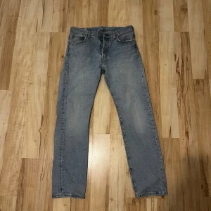 Levi's Premium jeans i ljusblå denim - Säljer ett par klassiska Levi's 501 jeans i ljusblå denim. De har en straight passform. Perfekta för en avslappnad stil. Notera att det finns slitningar vid bensluten. W30 L30