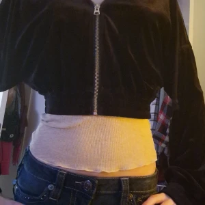 Svart sammet bomberjacka från Divided - Snygg svart bomberjacka i sammet från Divided. Den är croppad med dragkedja framtill och har långa ärmar. Perfekt för en trendig look!