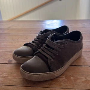Grå gröna lanvins - Snygga bruna sneakers från Lanvin med snörning och en stilren design. Skorna har en kombination av mocka och skinn vilket ger dem en lyxig känsla. Perfekta för en avslappnad men elegant stil.