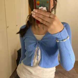 Blå ribbad kofta från Vero Moda - Säljer en snygg blå ribbad kofta från Vero Moda. Den har långa ärmar och en knytning framtill som ger en fin detalj. Perfekt för lager-på-lager-stil! 💙
