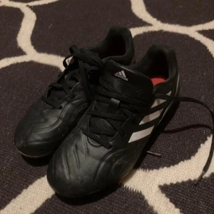 Svarta fotbollsskor Adidas Copa - Säljer ett par svarta fotbollsskor från Adidas med snörning. Skorna har en klassisk design och är perfekta för fotbollsplanen.