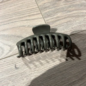 Grå hårklämma - Snygg och praktisk grå hårklämma i plast. Perfekt för att hålla håret på plats med stil. Klämman har en enkel och stilren design som passar till alla tillfällen.