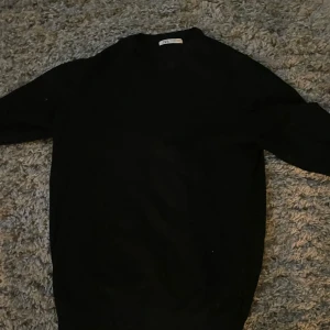 Svart tröja  - Säljer en stilren svart tröja från Filippa K. Tröjan har en klassisk design med långa ärmar och rund halsringning. Perfekt för en minimalistisk garderob. Passar till många olika stilar och tillfällen.