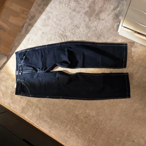 Mörkblå jeansbyxor från Levis - Snygga mörkblå jeansbyxor från Levis med klassisk design. Byxorna har raka ben och flera praktiska fickor. Perfekta för en stilren look. (Aldrig använts)