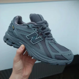 Grå sneakers från New Balance - Snygga grå sneakers från New Balance med robust design. Skorna har snörning och en bekväm sula med bra grepp. Perfekta för både vardag och träning. Nypris ca 1800kr. Priset kan diskuteras vid snabb affär!