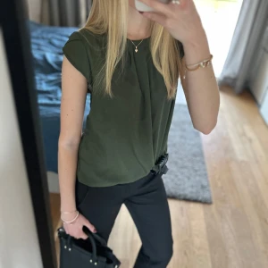 Olivgrön blus - Snygg olivgrön blus med korta ärmar och en elegant drapering framtill. ❤️❤️🙌🏻