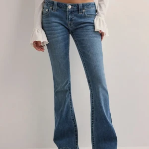 Blå bootcut jeans från True Religion - Snygga blå bootcut jeans från True Religion som är lågmidjade. De är uppsydda av en sömmerska och därav passar de mig som är 162 cm. Innerbenslängden är 72 cm och mått rakt över midjan är 41 cm. De är knappt använda och i mycket bra skick. De pr köpta på Nelly för 1399kr.