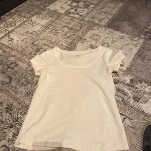 Vit kortärmad topp från 157 - Säljer en enkel och stilren vit kortärmad topp från 157. Perfekt basplagg med rund halsringning. Passar till många olika outfits och tillfällen.