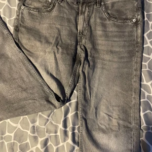 Grå jeans från 157 - Snygga grå jeans från 157 med klassisk femficksdesign. De har en rak passform och är perfekta för en avslappnad stil. Jeansen har en knappgylf och bälteshällor för extra funktionalitet. Skick: 10/10 W34 L32